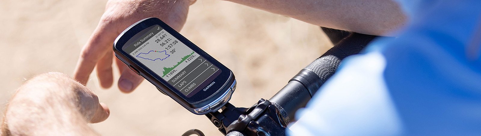 A cyclist checking a ride summary on a handlebar-mounted GPS computer